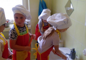 Dzieci myją marchewki w łazience.